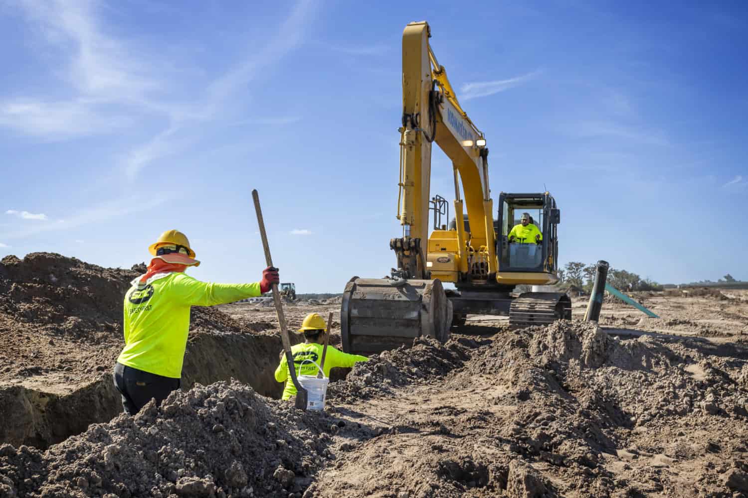 Heavy civil crew installing underground utility pipe on an SDC job site.