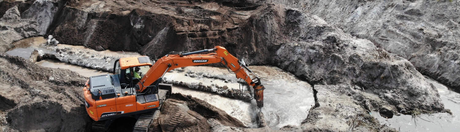 Excavator working on site for land development and grading for construction projects.