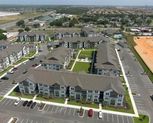 Aerial view of modern apartment complex showcasing well-planned site development, landscaped green spaces, and ample parking, highlighting professional site development services for residential communities.