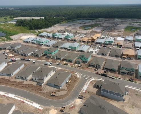 Aerial view of new residential construction site with multiple modern houses, ongoing development, and infrastructure setup, showcasing site development services by SDC.