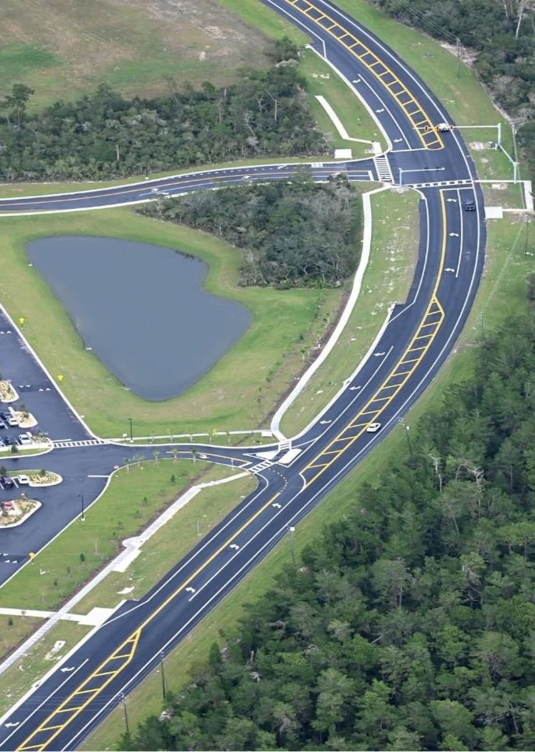 Modern road development with clear lane markings, pedestrian crossings, and landscape integration, showcasing site development and infrastructure planning.