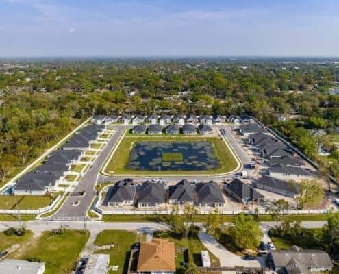 Modern residential community development with landscaped amenities and housing options.