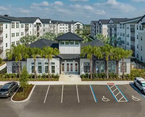 Modern residential apartment complex with landscaped surroundings and accessible parking in Florida, featuring contemporary architecture and amenities.