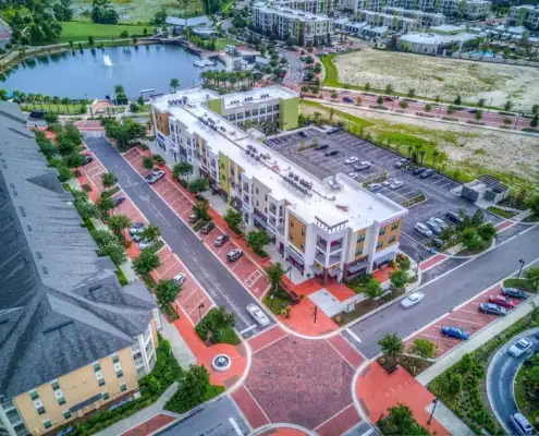 Modern mixed-use development with vibrant retail, residential units, and ample parking located near scenic water features and green spaces.