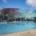 Colorful modern hotel building with poolside area, palm trees, and outdoor lounge chairs, showcasing innovative site development and contemporary architecture design.