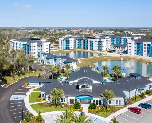 Modern residential apartment complex with landscaped grounds, lakes, and parking, demonstrating professional site development and smart urban planning.