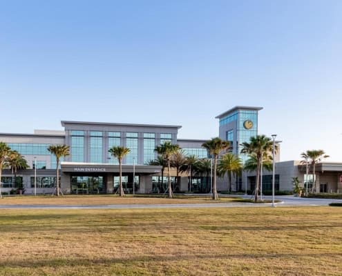 Modern commercial building with glass facade and landscaped surroundings for site development services.
