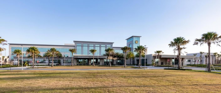 Modern commercial building with glass facade and landscaped surroundings for site development services.