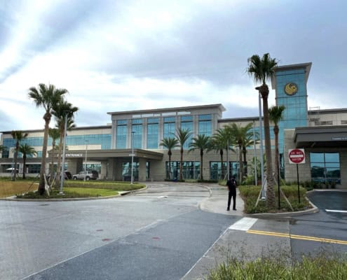 Modern commercial building with glass facade and palm trees, showcasing professional site development and architecture in Florida.