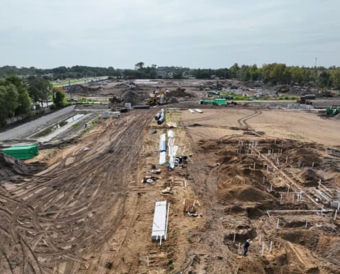 Excavation and site development process with heavy machinery and construction materials for building infrastructure.