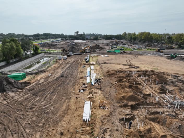 Excavation and site development process with heavy machinery and construction materials for building infrastructure.