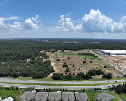 Open land development site in Florida with commercial and residential neighborhoods, focusing on site development, land planning, and infrastructure development for future growth.