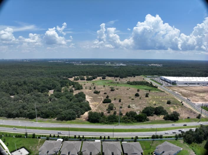 Open land development site in Florida with commercial and residential neighborhoods, focusing on site development, land planning, and infrastructure development for future growth.