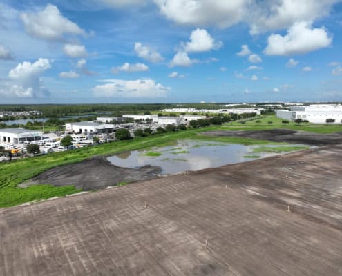 Progress in commercial site development with grading, excavation, and foundation preparation at an industrial construction project.