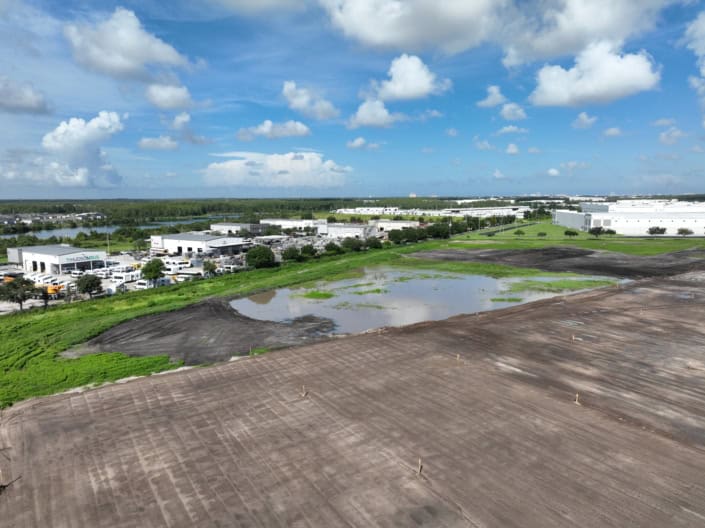 Progress in commercial site development with grading, excavation, and foundation preparation at an industrial construction project.