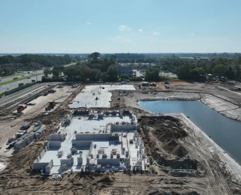Modern commercial building construction site with foundation work and concrete pouring, showcasing advanced site development and infrastructure planning.