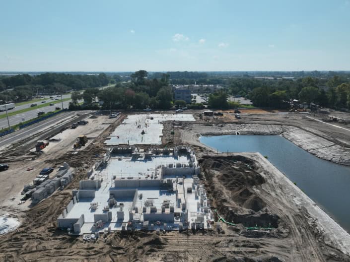 Modern commercial building construction site with foundation work and concrete pouring, showcasing advanced site development and infrastructure planning.