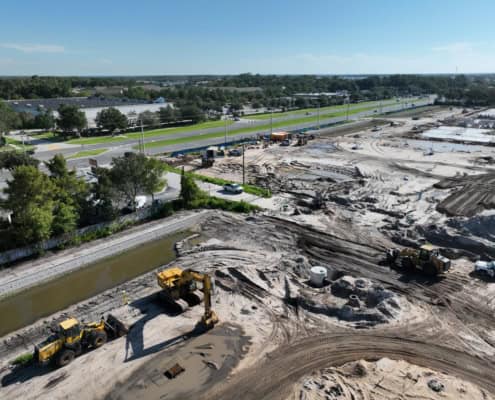 Excavation and site development for commercial construction with heavy machinery and earth-moving equipment.