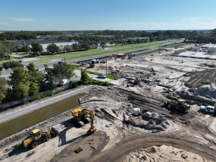 Excavation and site development for commercial construction with heavy machinery and earth-moving equipment.