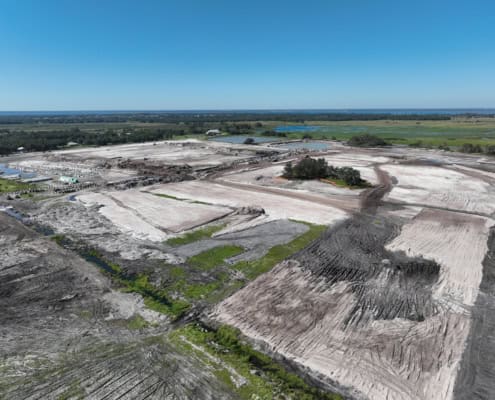 Aerial view of site development for commercial or industrial construction, showing cleared land, grading, and infrastructure preparation for new building projects.