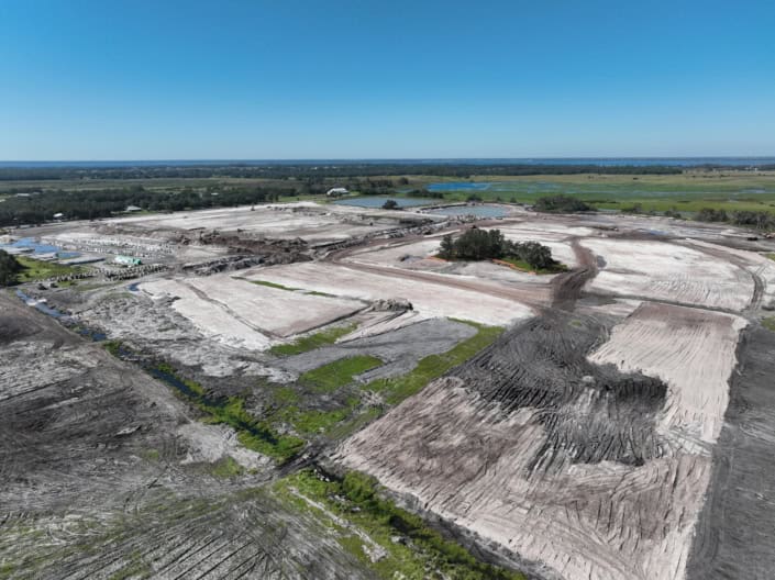 Aerial view of site development for commercial or industrial construction, showing cleared land, grading, and infrastructure preparation for new building projects.