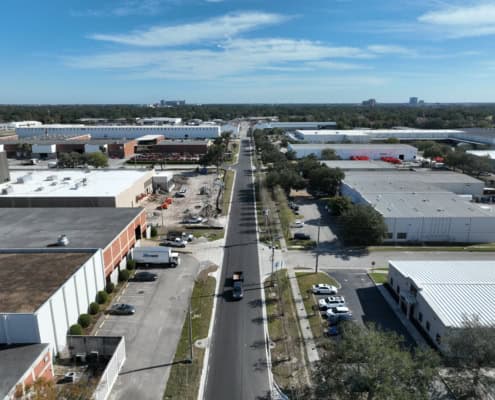 Aerial view of industrial and commercial warehouse buildings with ongoing construction and loading docks, showcasing site development and infrastructure improvements.