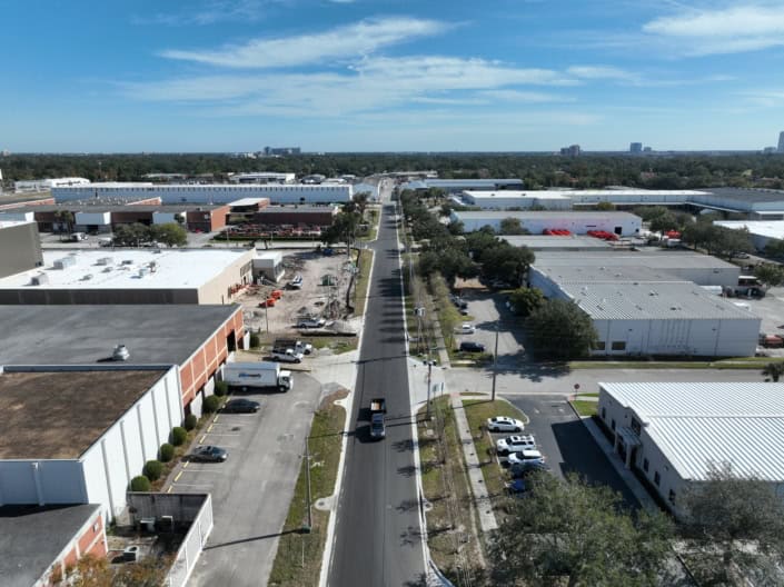 Aerial view of industrial and commercial warehouse buildings with ongoing construction and loading docks, showcasing site development and infrastructure improvements.