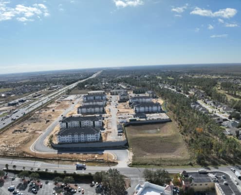 Modern residential community under construction with multiple apartment buildings and ongoing site development and infrastructure.