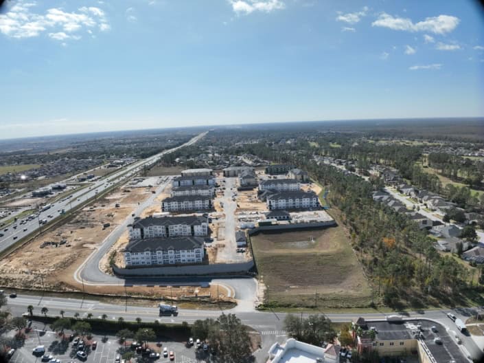 Modern residential community under construction with multiple apartment buildings and ongoing site development and infrastructure.