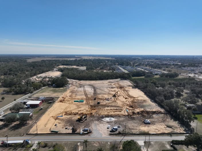 Clear construction site for commercial development with heavy machinery and land preparation, showcasing site development, excavation, and planning for a new business facility.