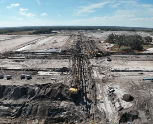 Site development and construction progress at an industrial land project, showcasing earthmoving, site grading, and utility installation for commercial development.