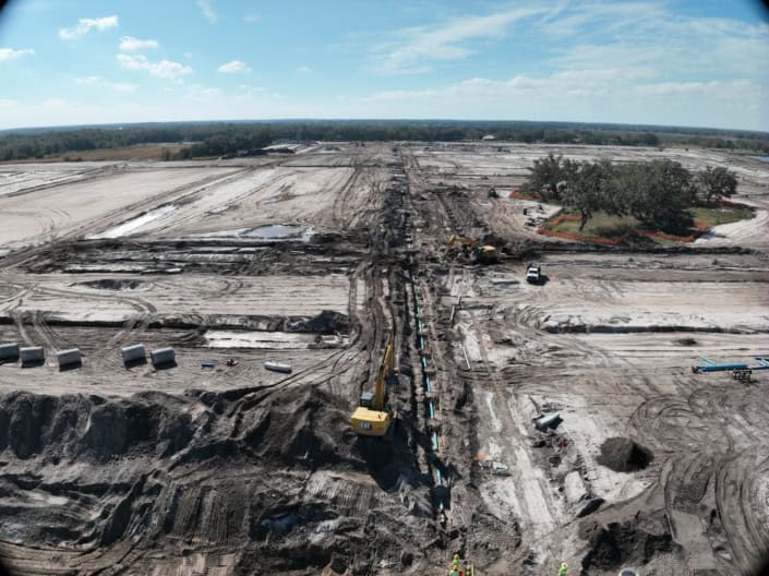 Site development and construction progress at an industrial land project, showcasing earthmoving, site grading, and utility installation for commercial development.