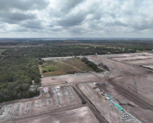 Aerial view of the early stages of site development for a commercial or industrial project, showcasing land clearing, grading, and construction preparation for infrastructure.