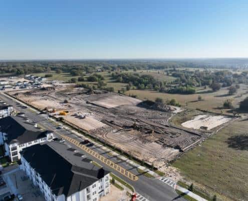 Excavation site for new residential or commercial development with construction equipment and cleared land, illustrating site development for real estate projects.