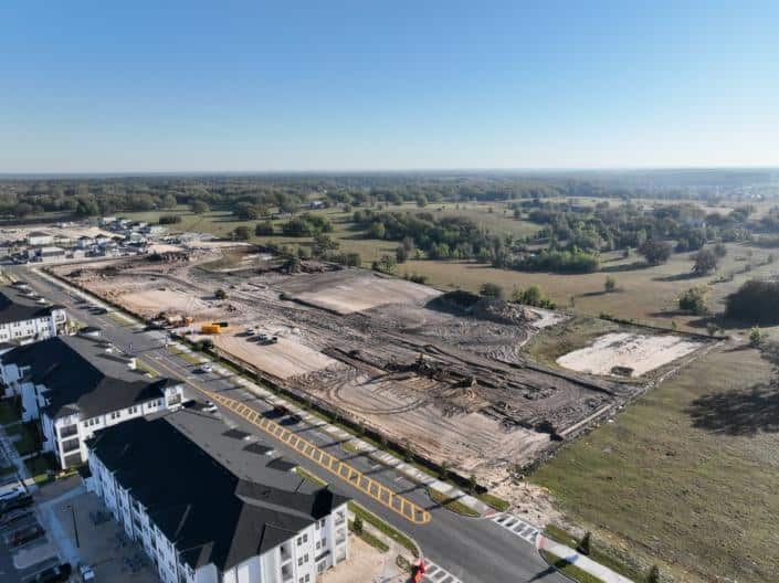 Excavation site for new residential or commercial development with construction equipment and cleared land, illustrating site development for real estate projects.