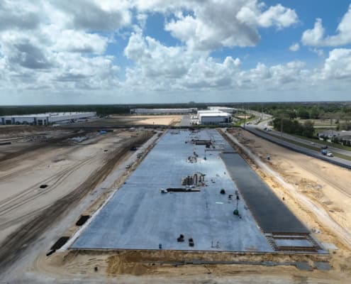 Modern commercial building construction site under development with concrete foundation in progress.