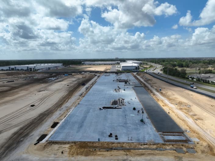 Modern commercial building construction site under development with concrete foundation in progress.