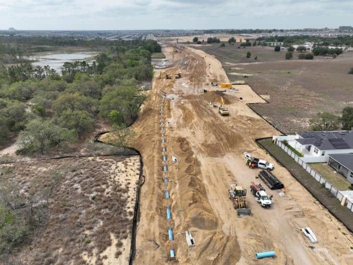 Earth-moving construction site for residential development, showcasing site clearing, excavation, and infrastructure installation in progress.