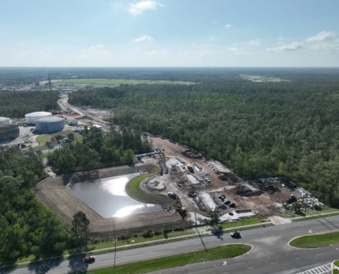 Constructing industrial site with fuel tanks, warehouses, and paved areas demonstrating professional site development services.