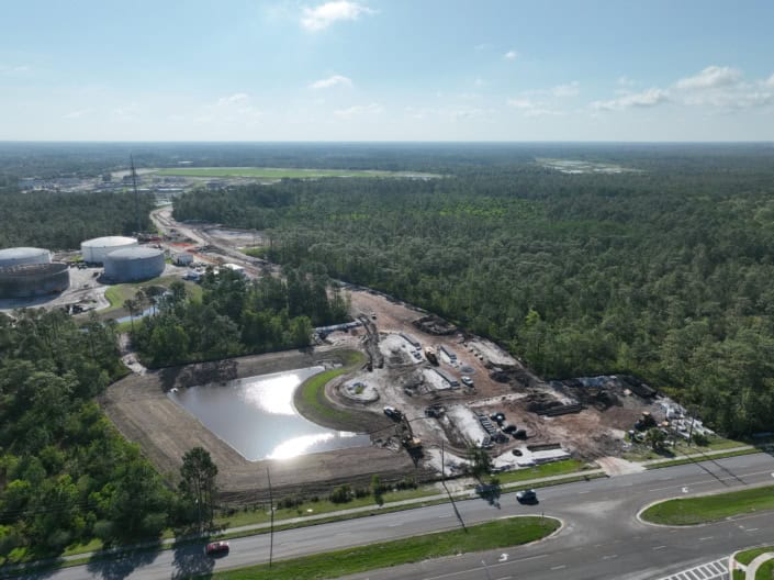 Constructing industrial site with fuel tanks, warehouses, and paved areas demonstrating professional site development services.