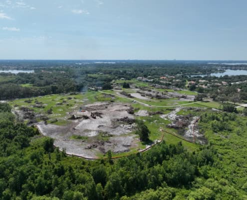 Excavation site for new commercial development showing cleared land and construction equipment, emphasizing site development and land preparation services.