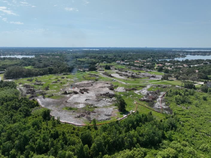 Excavation site for new commercial development showing cleared land and construction equipment, emphasizing site development and land preparation services.
