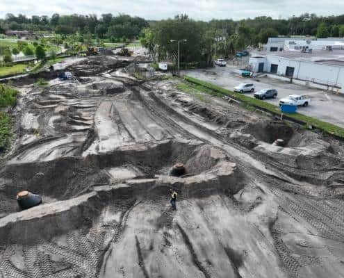 Excavation site for commercial development with heavy machinery and marked groundwork, showcasing construction progress and land preparation for new building projects.