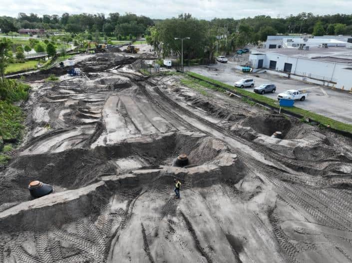 Excavation site for commercial development with heavy machinery and marked groundwork, showcasing construction progress and land preparation for new building projects.