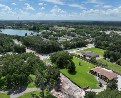 Aerial view of residential neighborhood with ongoing site development projects and lush greenery, showcasing landscape design, infrastructure improvements, and urban planning efforts.