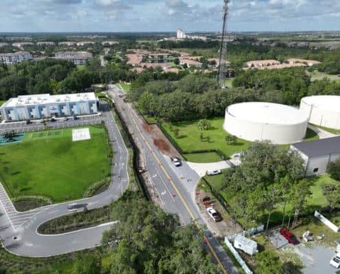 Modern commercial site development with underground utilities and landscaping, featuring water tanks, recreation areas, and accessible parking for optimized urban infrastructure.