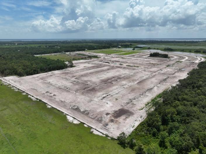 Large construction site development in progress with extensive land clearing and grading for new commercial or industrial project.