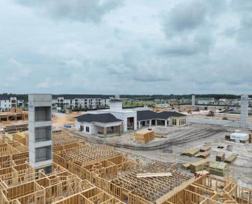 Modern residential development site with extensive construction in progress, showcasing framing, early building phases, and infrastructure for custom homes, emphasizing site development expertise.