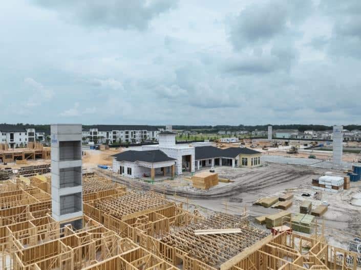Modern residential development site with extensive construction in progress, showcasing framing, early building phases, and infrastructure for custom homes, emphasizing site development expertise.