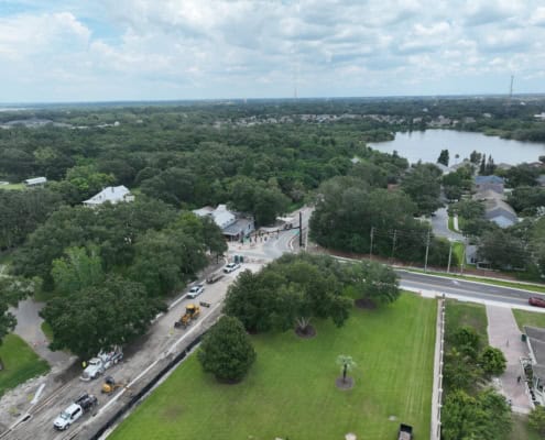 Aerial view of residential neighborhood with site development construction, green landscaping, and surrounding lakes, showcasing professional site development services.
